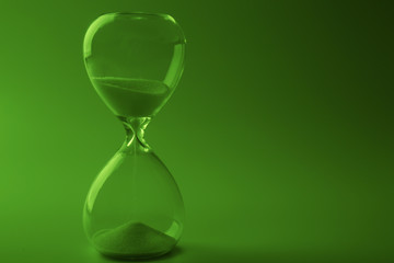 Hourglass on green background
