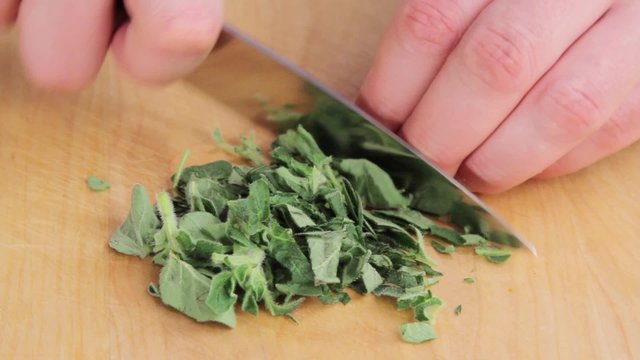 Finely chopping oregano leaves