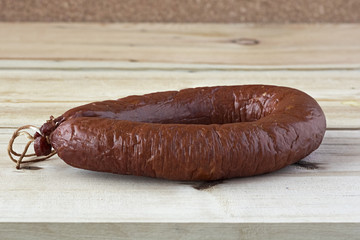 A Cracow sausage on a wooden table