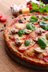 Tasty pizza with vegetables and basil on table close up