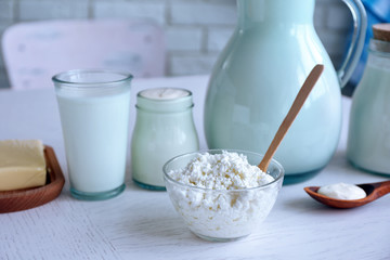 Dairy products on wooden table, on brick wall background