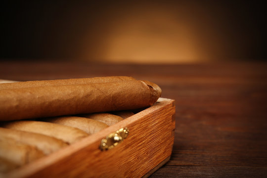 Cigars in humidor on wooden table, closeup