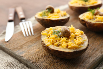 Baked potatoes with cheese and mushrooms on table close up