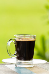 Black coffee on nature background.