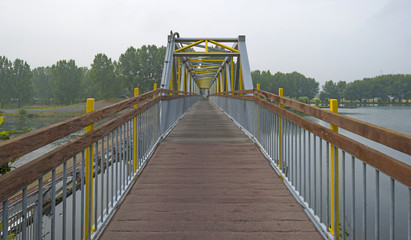 Obraz premium Footbridge over a river in summer