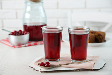 Sweet homemade cherry compote on table, on light background