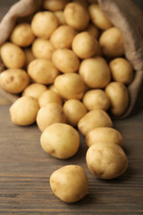 Fototapeta na wymiar New potatoes on wooden table, closeup