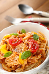 Homemade Spaghetti Bolognese with parmesan cheese in white bowl, on color wooden background
