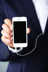 Music smartphone in businessman hand, close-up