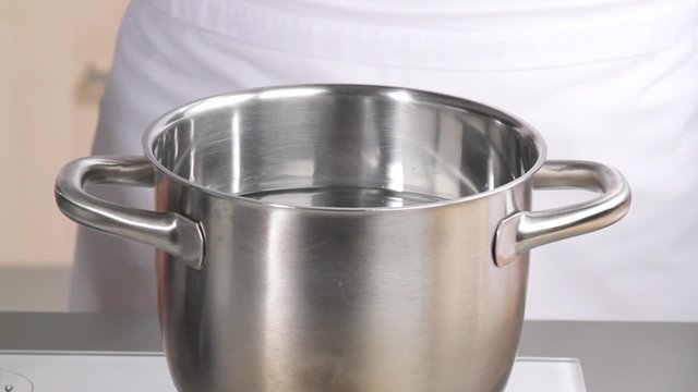 Salt being added to a saucepan of water