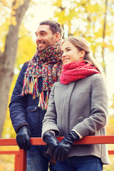 Fototapeta premium smiling couple hugging on bridge in autumn park