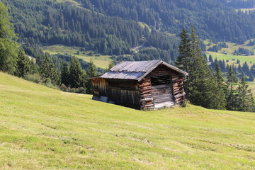 Obraz premium A wooden ski hut on Alp mountains with green meadow in Fiss, Tirol, Austria. 
