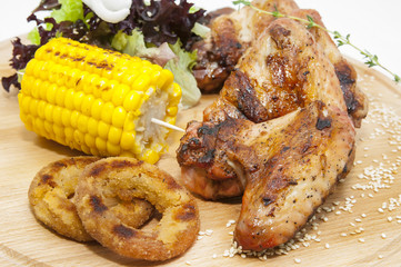 chicken wings are grilled on a wooden platter