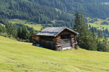 Fototapeta na wymiar A wooden ski hut on Alp mountains with green meadow in Fiss, Tirol, Austria. 