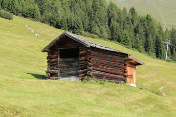 Obraz premium A wooden ski hut on Alp mountains with green meadow in Fiss, Tirol, Austria. 