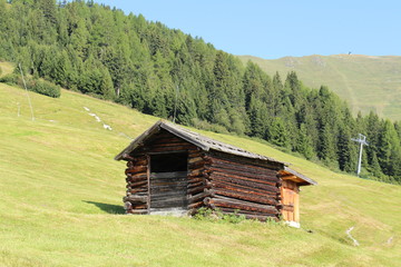 Obraz premium A wooden ski hut on Alp mountains with green meadow in Fiss, Tirol, Austria. 