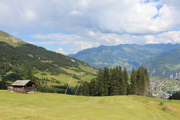 Fototapeta na wymiar A wooden ski hut on Alp mountains with green meadow in Fiss, Tirol, Austria. 
