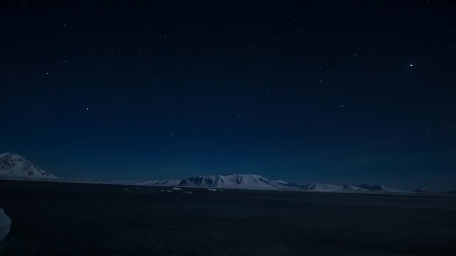 Winter in Arctic. Starry sky in the polar night. Northern Lights over Spitsbergen.