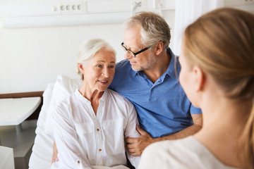 happy family visiting senior woman at hospital