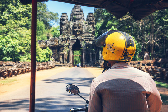 A tucutuc driver (motorbike-taxi) entering Ankor Thom temple com
