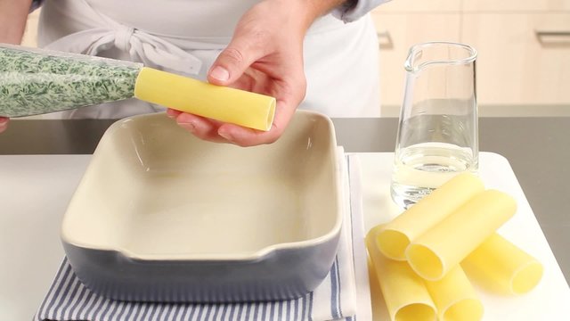 Cannelloni being filled with a spinach and ricotta mixture