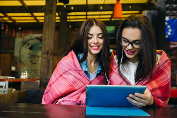 two close friends watching something on a tablet