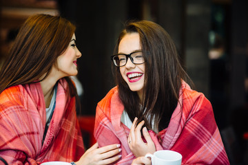 Two young and beautiful girls gossiping