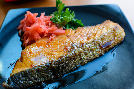 Salmon steak and ginger preserves in  black dish