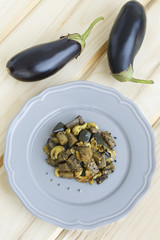 Top view of the eggplant and a plate of ragout. Food on a wooden background