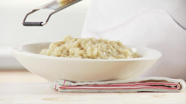 Scattering parmesan over risotto