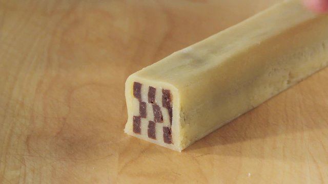 Cutting chocolate and vanilla biscuit dough into thin slices