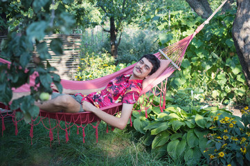 a young man lies  in a red hammock