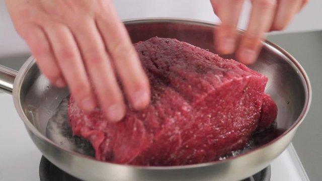 Sealing joint of beef in a frying pan