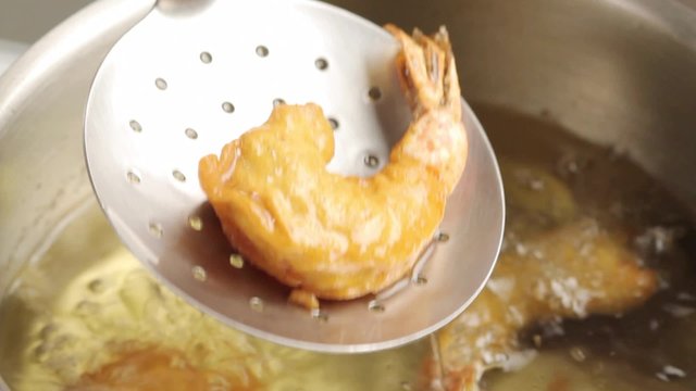 Removing deep-fried prawns from oil