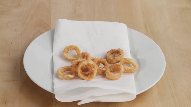 Draining deep-fried calamari on kitchen paper