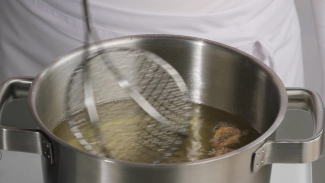 Removing deep-fried calamari from oil