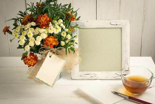 Retro photo frame and old pen with sheet paper and tagetes bouquet