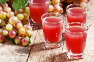 Grape juice pink grapes with fresh berries, selective focus