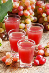 Grape juice pink grapes with fresh berries, selective focus