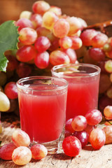 Grape juice pink grapes with fresh berries, selective focus
