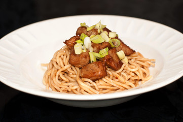 Chinese noodles with stir fried pork and green onions