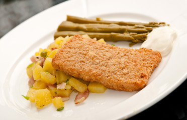 Fish breaded fillet with potatoes and aspartagus.