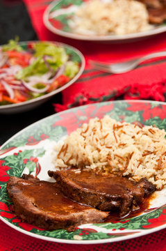 Typical venezuelan christmas food: "asado negro" with rice and salad. "Asado negro" is beef with a dark sweet sauce.