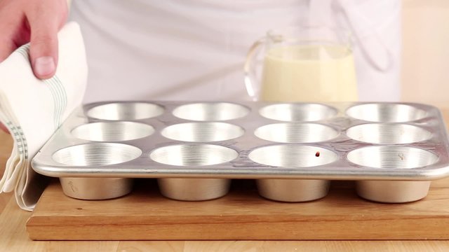 Yorkshire pudding batter being poured into a muffin tin