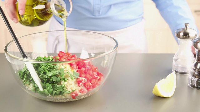 Ingredients for tabbouleh being seasoned
