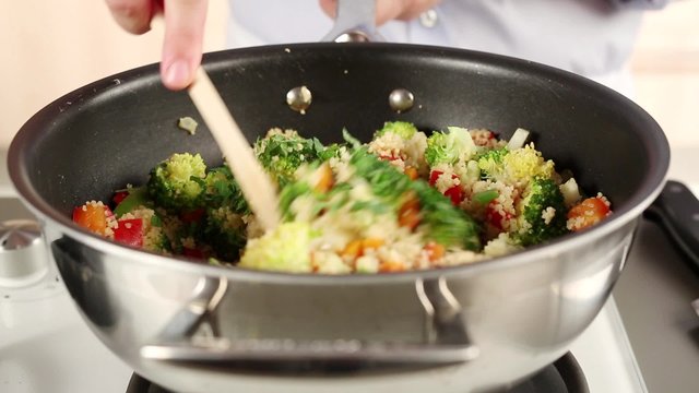 Vegetable couscous being sprinkled with parsley