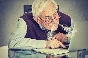 Stressed elderly man using computer