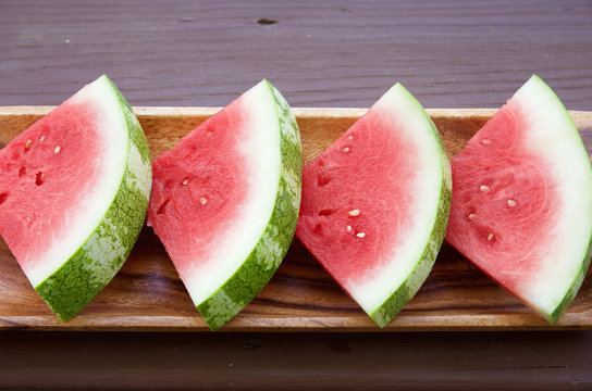 Slices of seedless watermelon on wooden background