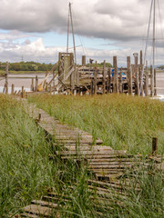 Fototapeta premium Skipool Creek, Thornton Cleveleys, Lancashire, UK. August 11th 2015. Wooden piers at low tide at Skipool Creek, Lancashire, uk.