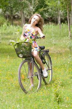 Teenage girl with her bicycle in forest